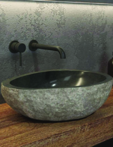 River stone vessel basin with a rough natural outer surface and polished dark interior
