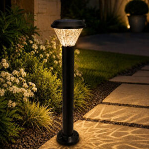 Tall solar pathway bollard with a faceted head casting a patterned glow on paving