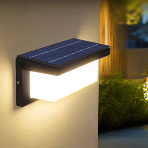 Solar wall light with an angled panel above a wide illuminated diffuser